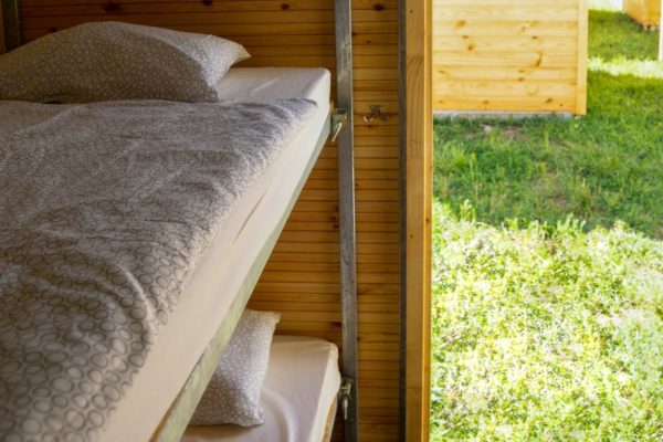 Cosy Event Lodge from inside with two bunk beds on the left and bed linen