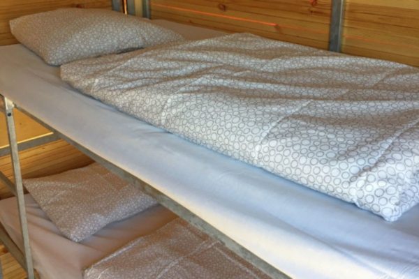 Cosy Event Lodge from inside with two bunk beds on the right and bed linen