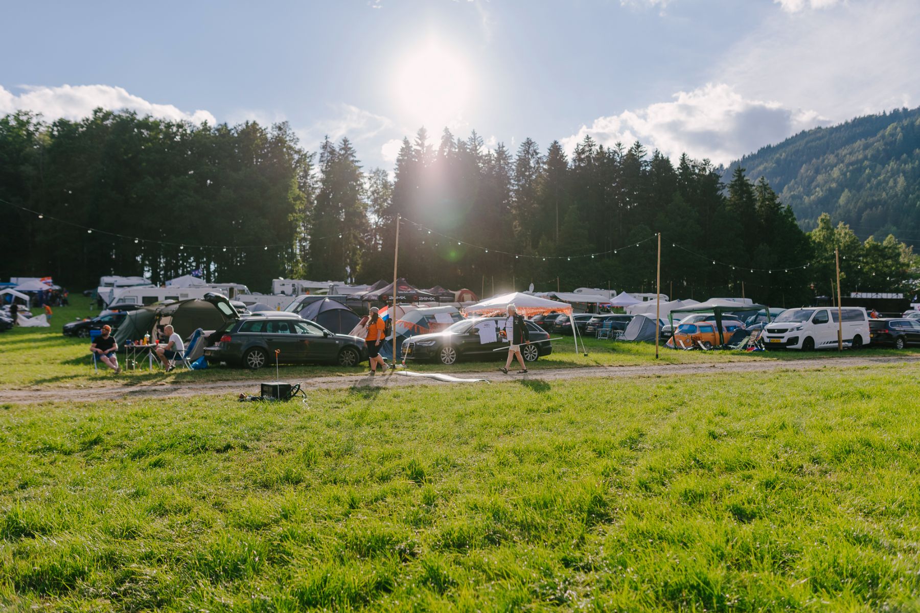 Pitches on the Green Area with tents and cars, green meadow
