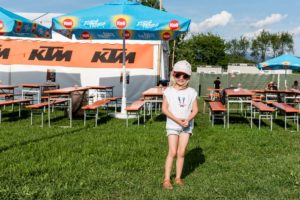 Child in front of KTM banner and guest garden